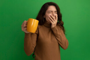 Woman with a cup covering her mouth