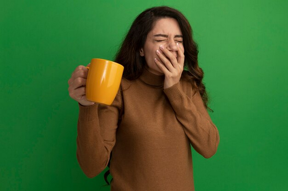 Woman with a cup covering her mouth