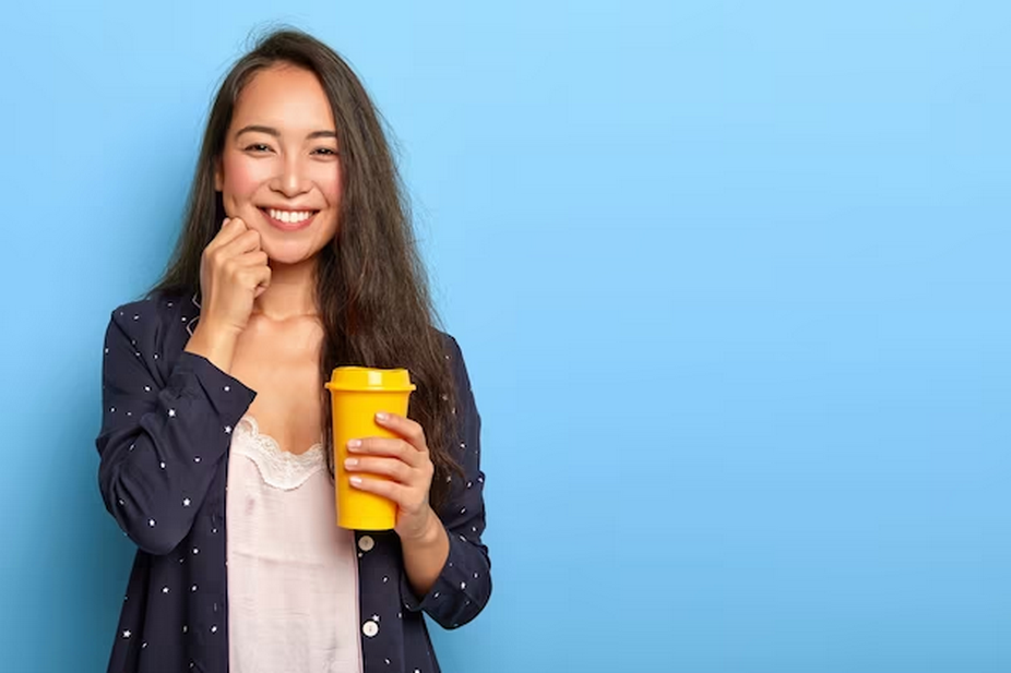 Woman with a yellow cup holding her cheeks.